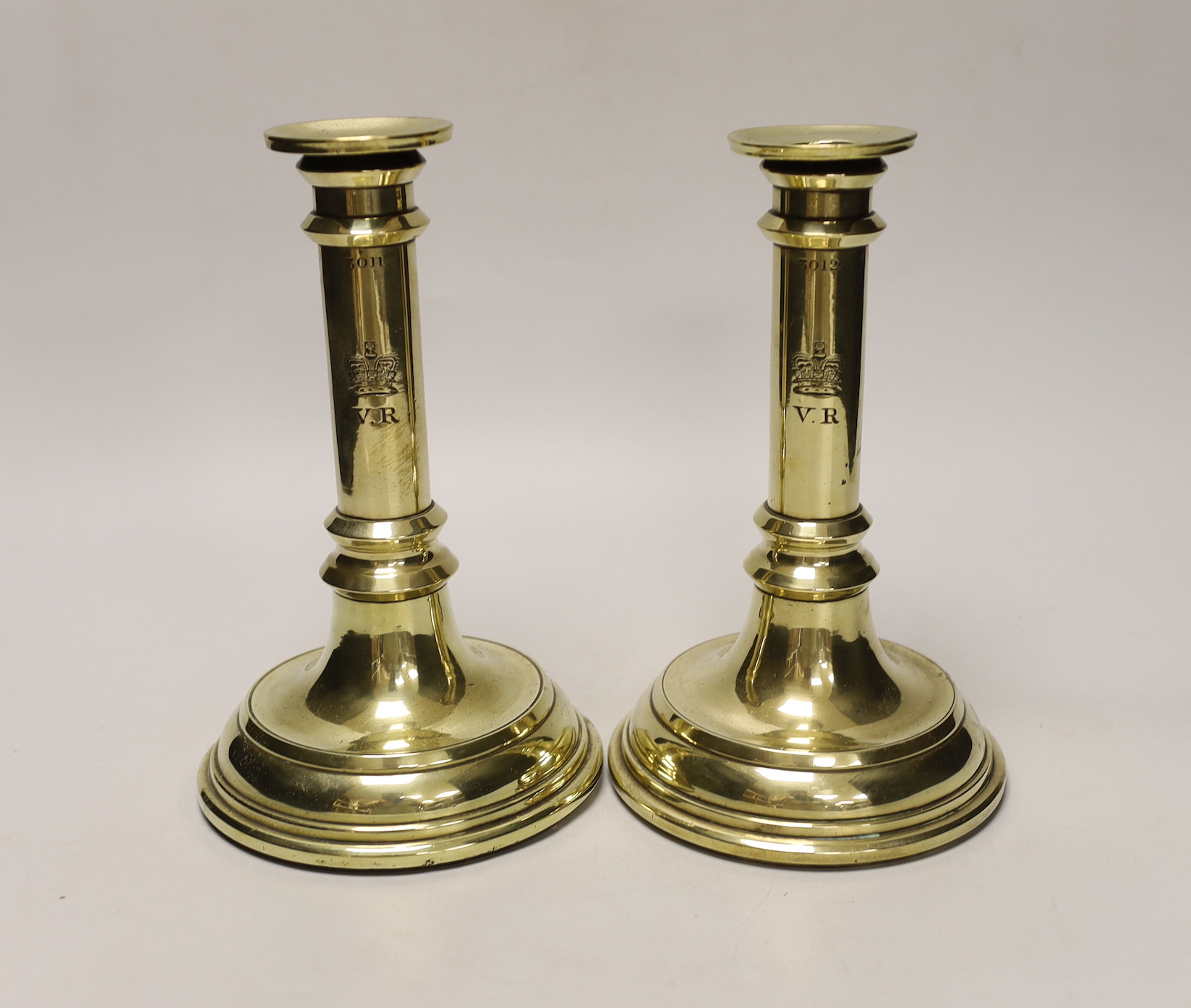 A pair of Victorian brass candlesticks possibly from House of Commons or military consecutively numbered, 21.5cm tall